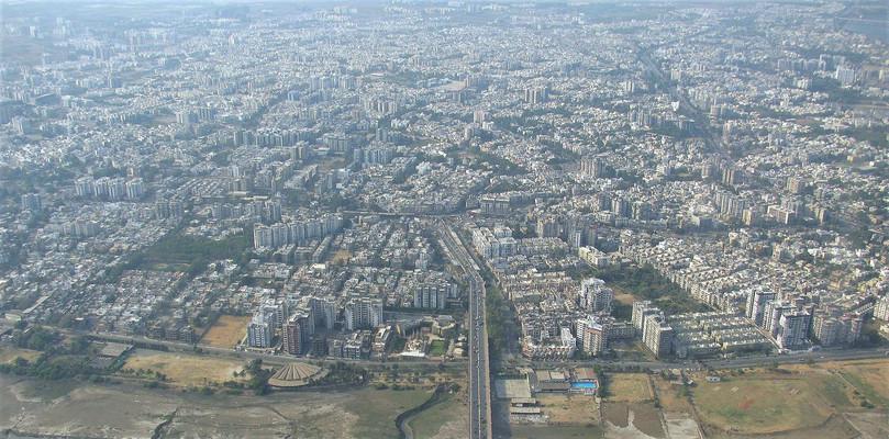 b. An aerial view of Surat showing dense urbanisation near the Tapi river
: A photograph of Surat showing urbanisation near the Tapi river.
